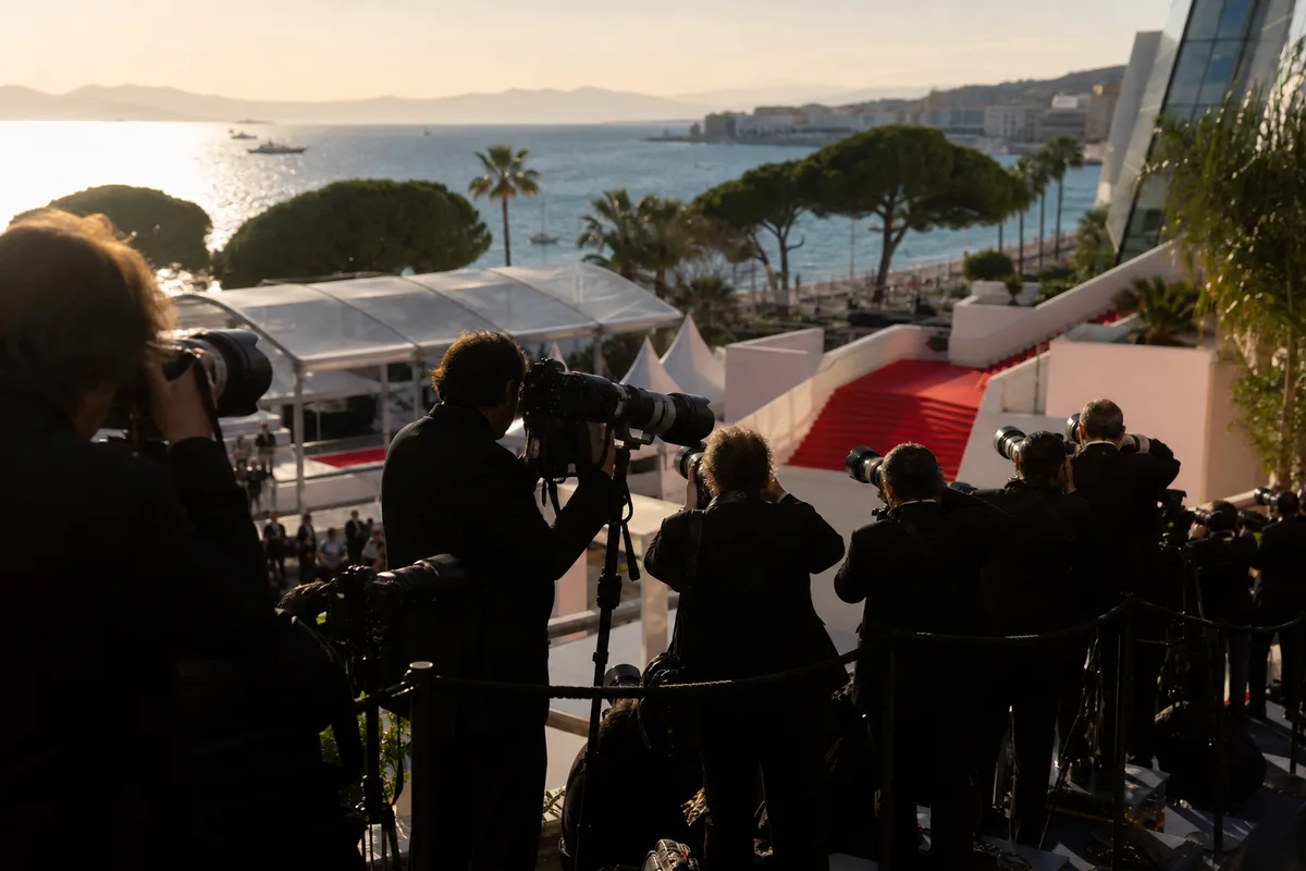 Photographes accrédités alignés sur un praticable face aux marches du Palais des Festivals